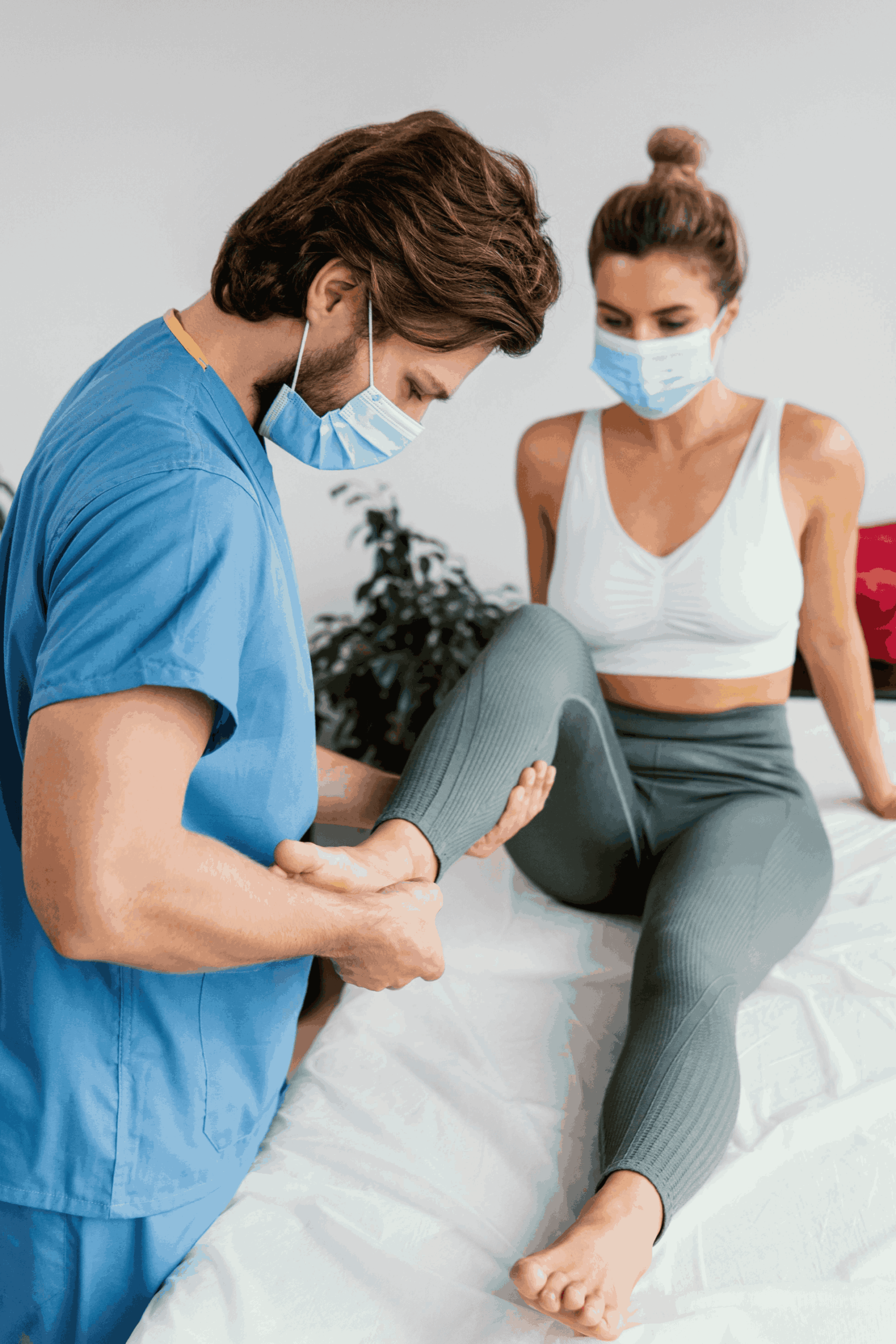 side-male-osteopathic-therapist-with-medical-mask-checking-female-patient-s-ankle (1)
